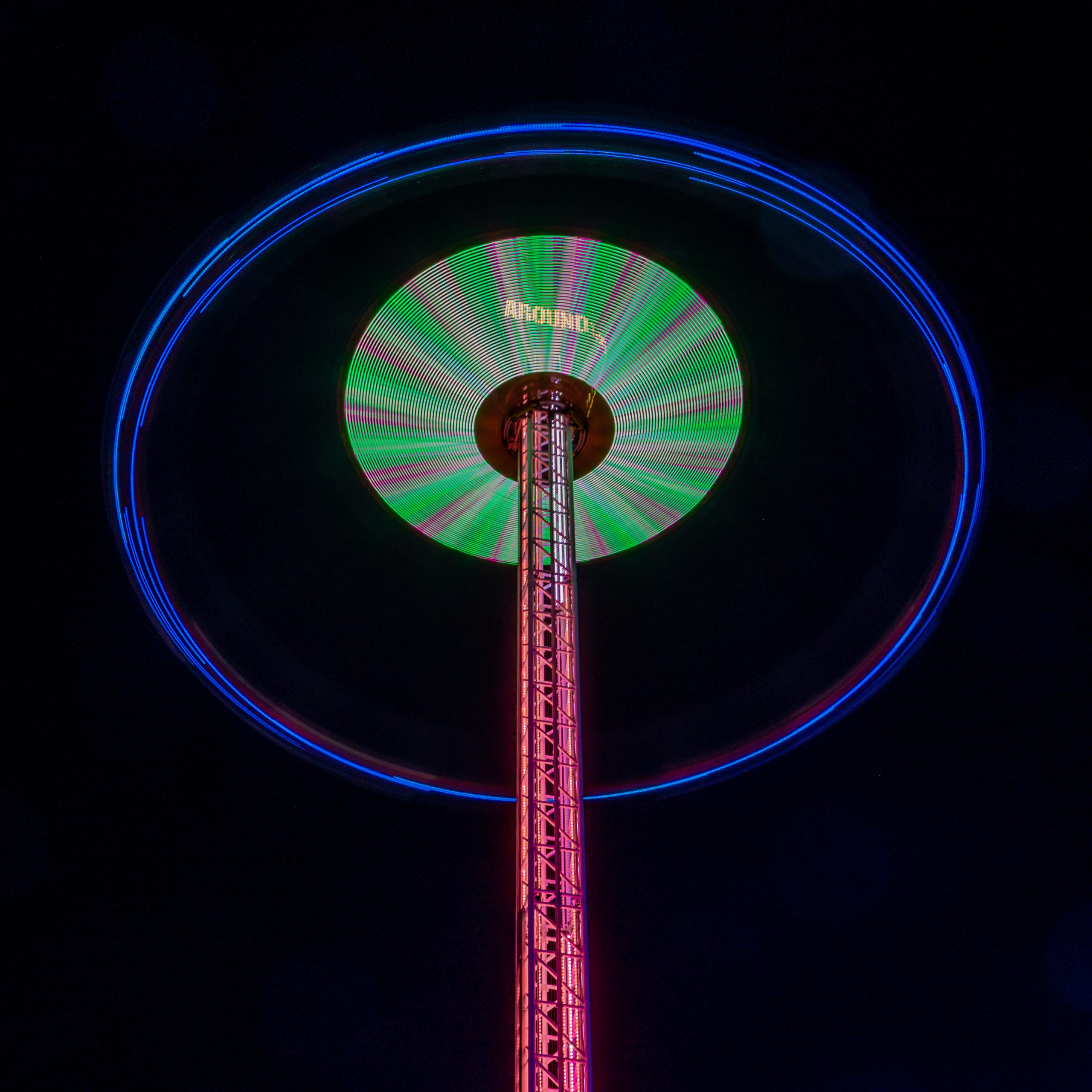 Zweefmolen hoog in de avond met neon